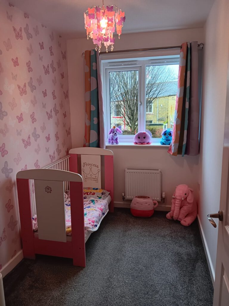 Child’s bedroom with pink butterfly wallpaper