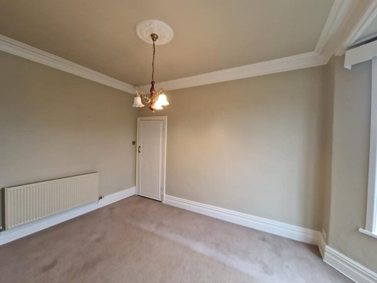 Freshly painted cream room with white coving and ceiling rose
