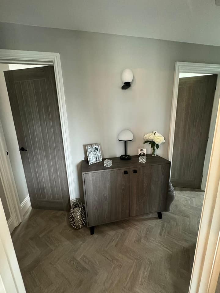 Grey painted hallway with oak-effect doors and herringbone floor