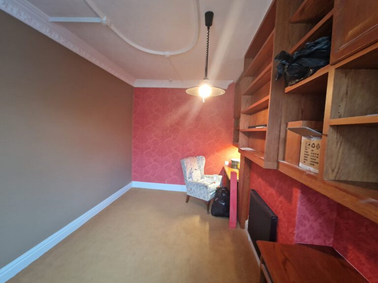 Red patterned wallpaper feature wall with taupe painted walls