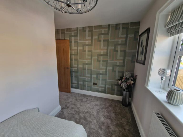 Bedroom with green geometric feature wallpaper