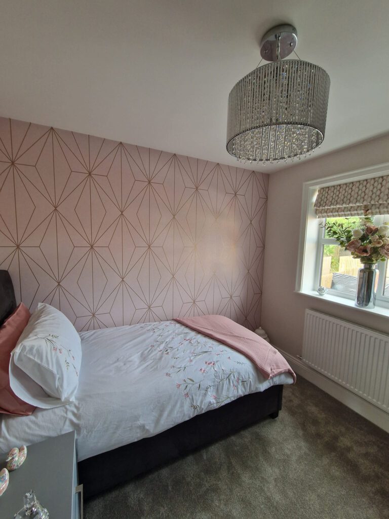 Bedroom with blush pink geometric wallpaper