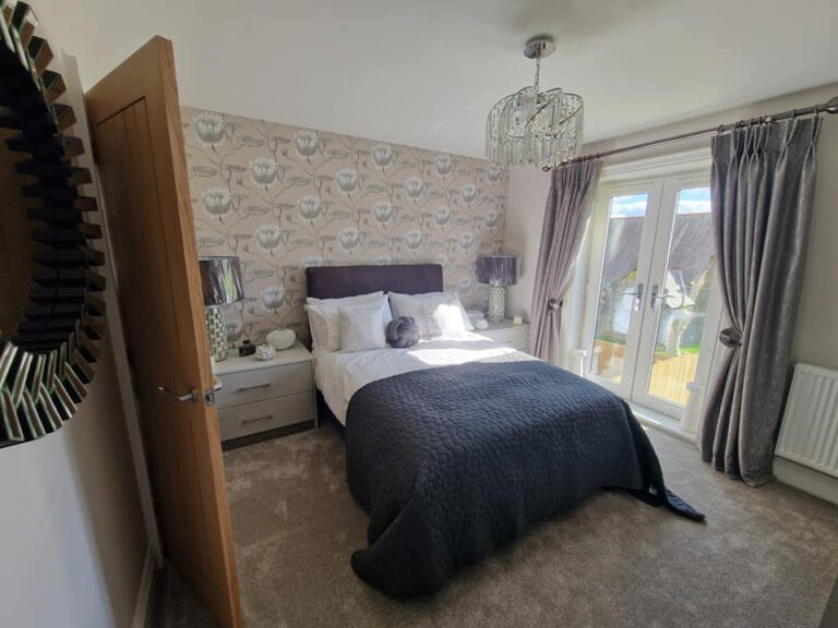 Bedroom with patterned feature wallpaper and French doors