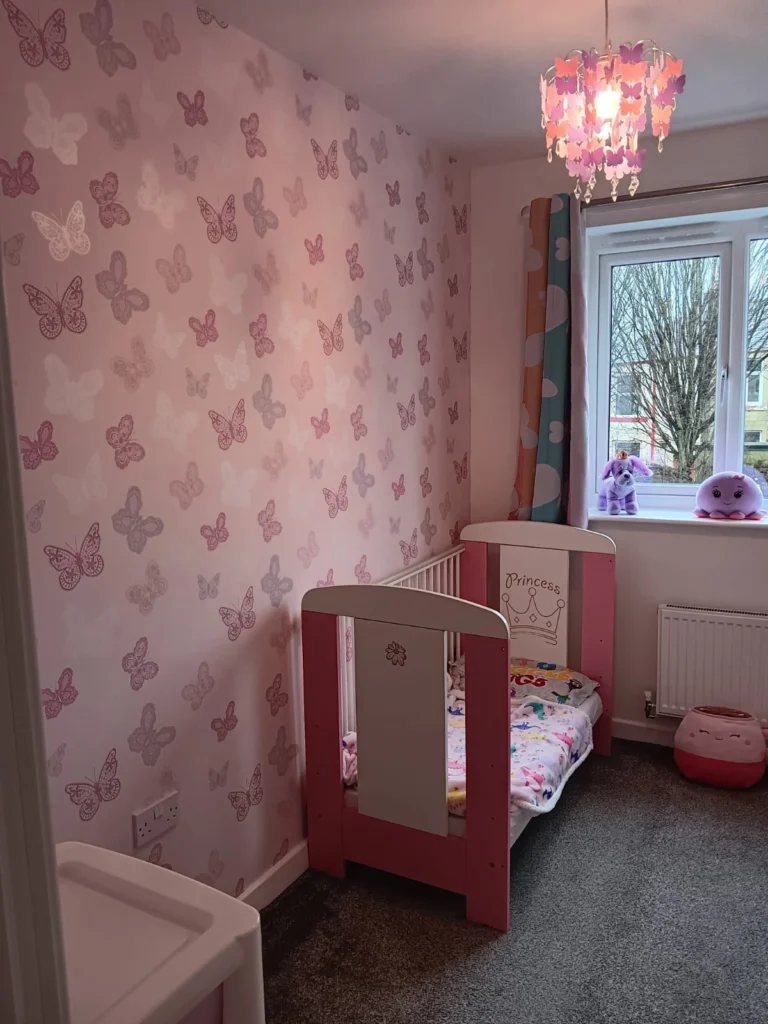 Child’s bedroom with pink butterfly wallpaper